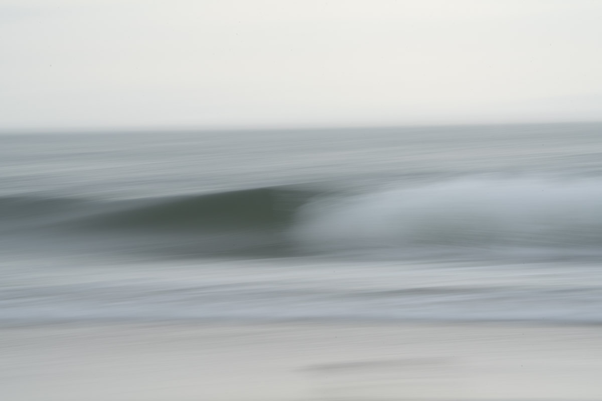 A blurry picture of the ocean with waves in it.