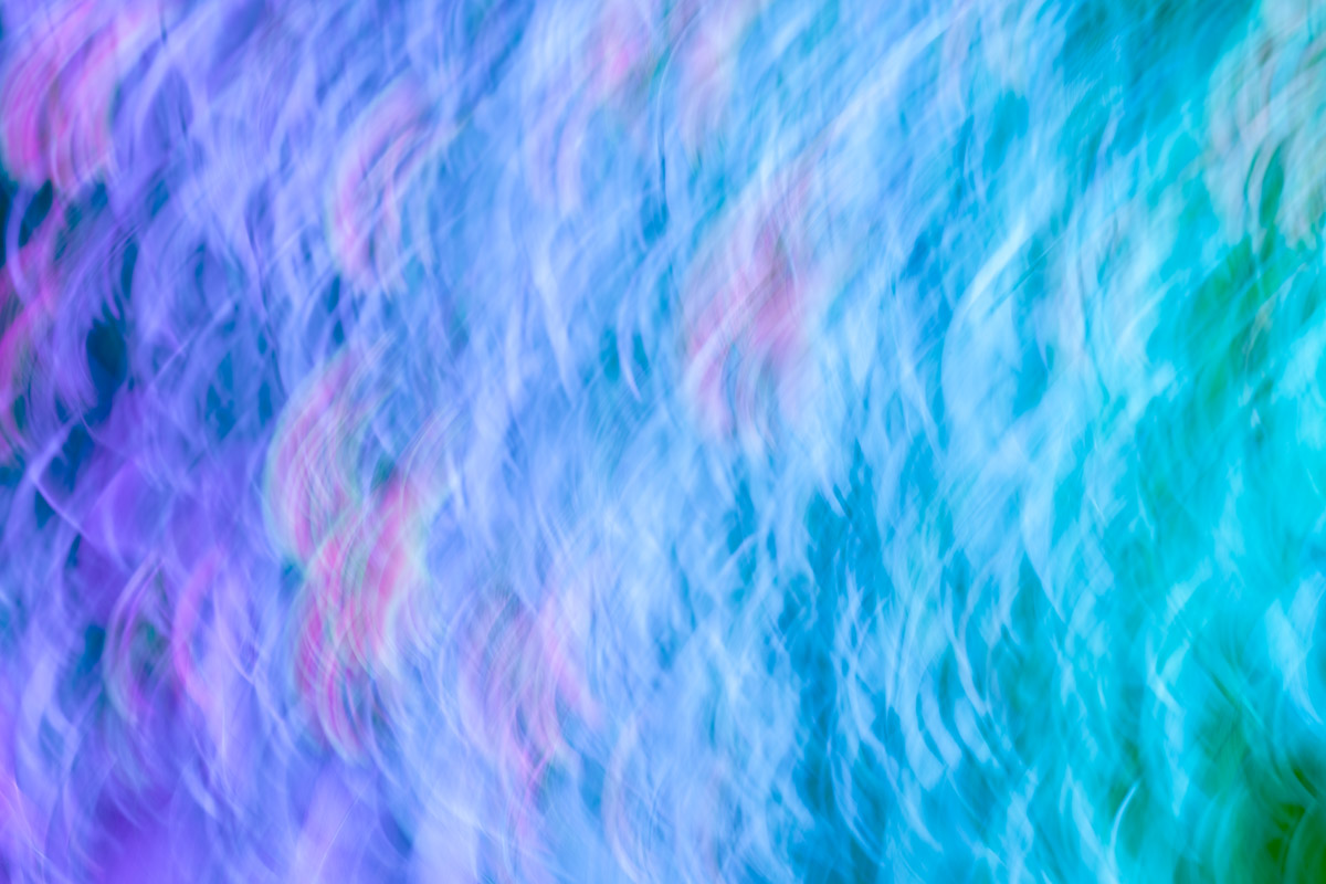 A blurry image of water with pink and blue colors.