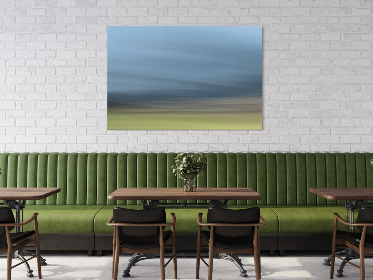 A painting of a field in the middle of a room.